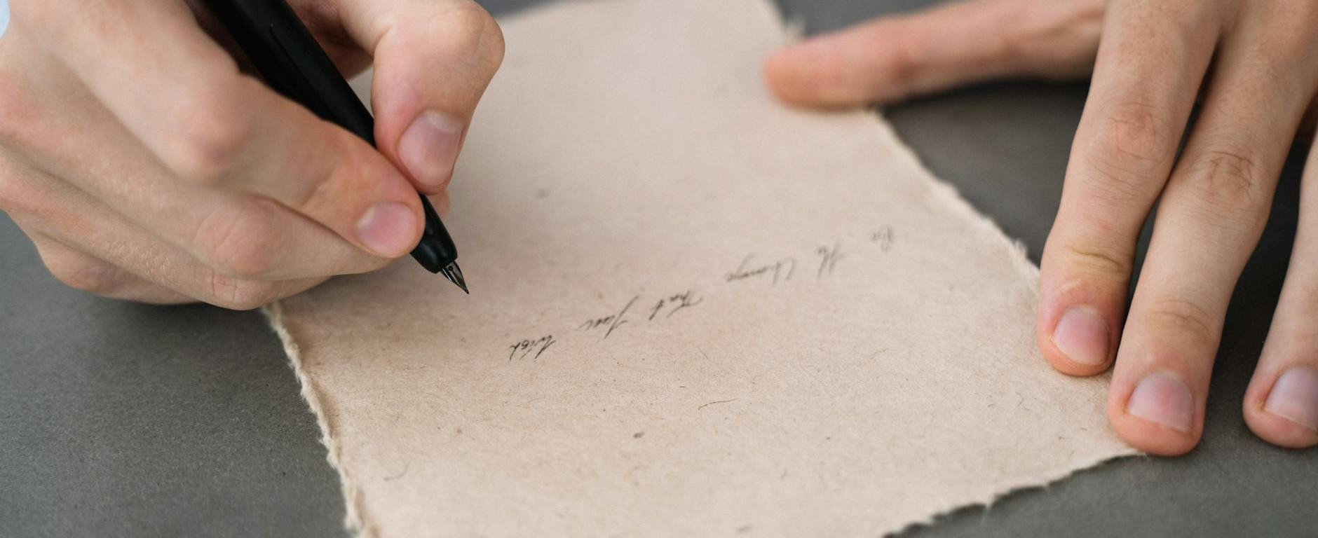 close up shot of a person writing on a paper